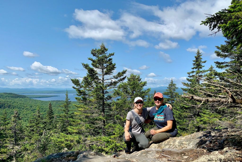 Tamara Gruber and Kim Tate sitting at the top of Little Mt Kineo in Maine