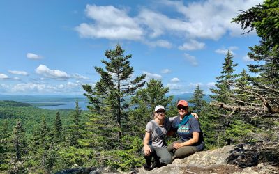 Tamara Gruber and Kim Tate sitting at the top of Little Mt Kineo in Maine