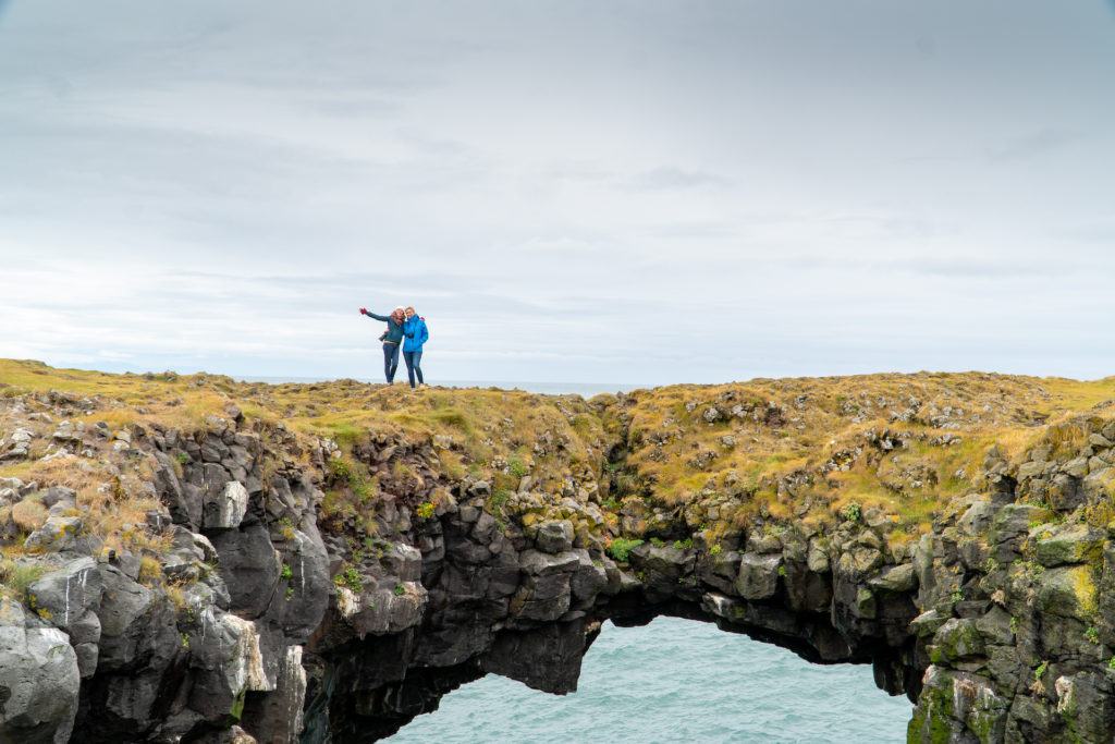 Two friends standing on the Arnarstapi cliffs land bridge