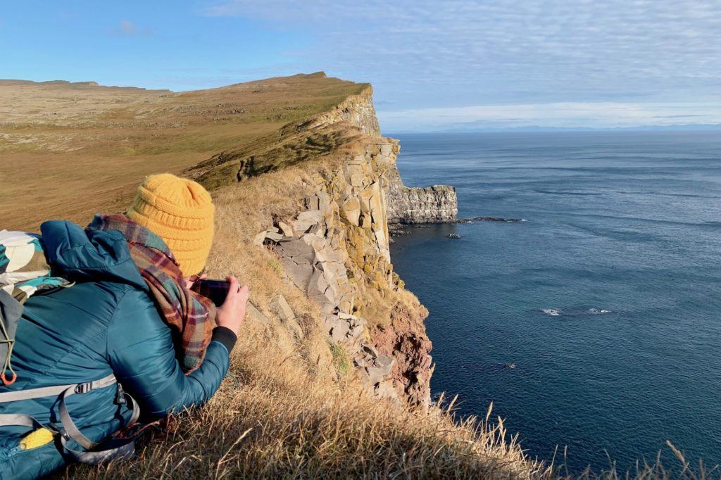 photographer leaning over Latrabarg cliffs