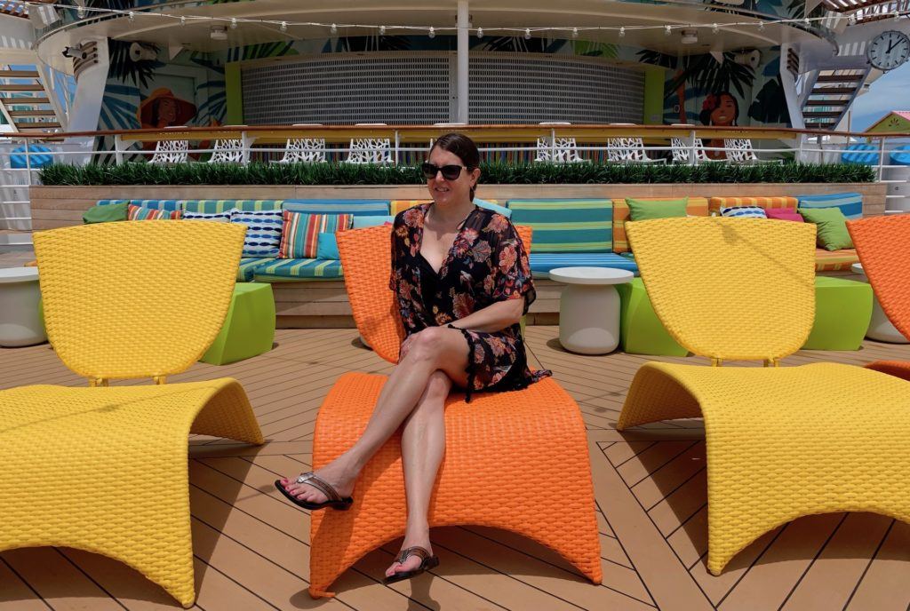 Tamara on orange chair on the cruise ship pool deck