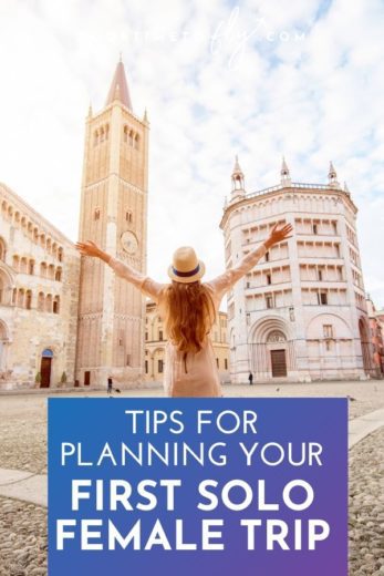 Tips for planning your first solo female trip woman with arms up looking at buildings in Italy