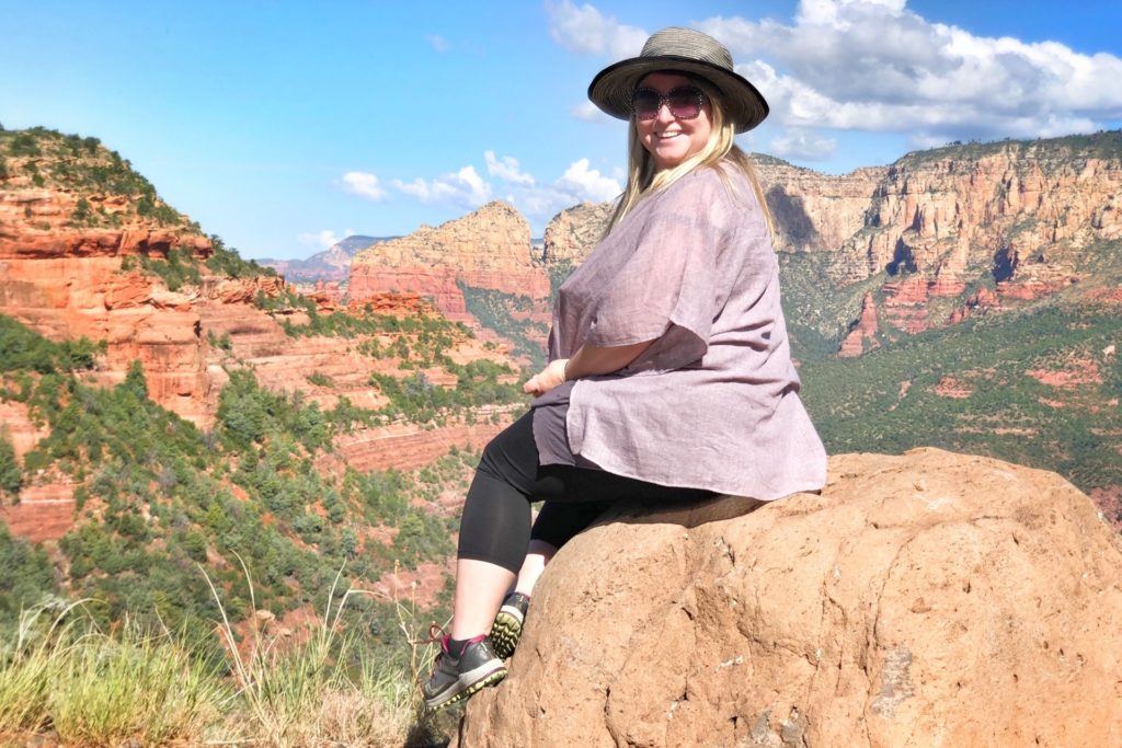 Karilyn Owen in the desert sitting on a rock