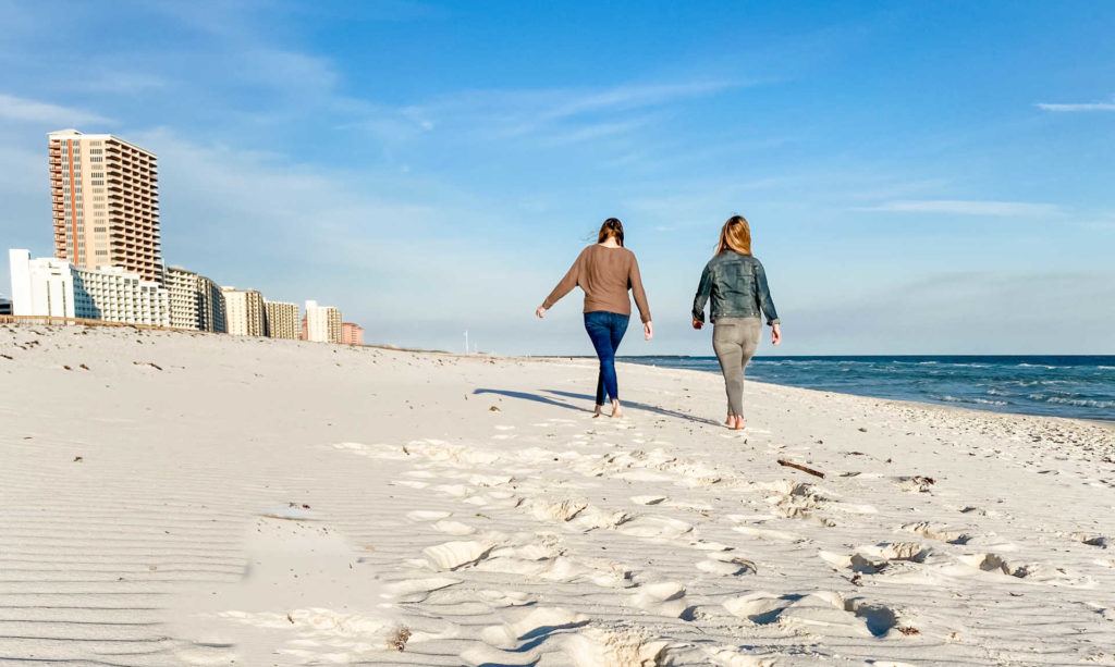 two women walking on beach