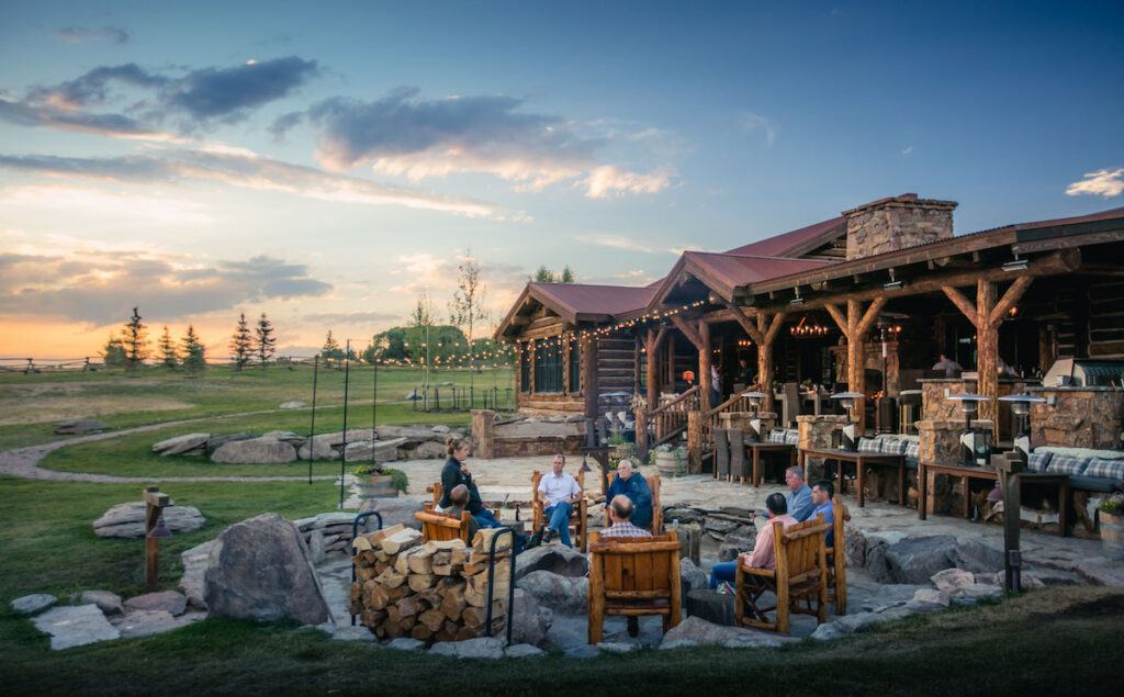 people gathered around a fire pit at sunset at Magee Homestead ranch