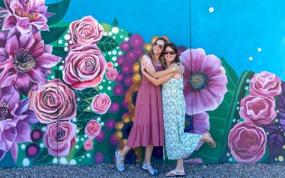 Kim Tate and Tamara Gruber hugging in front of mural in Tempe AZ