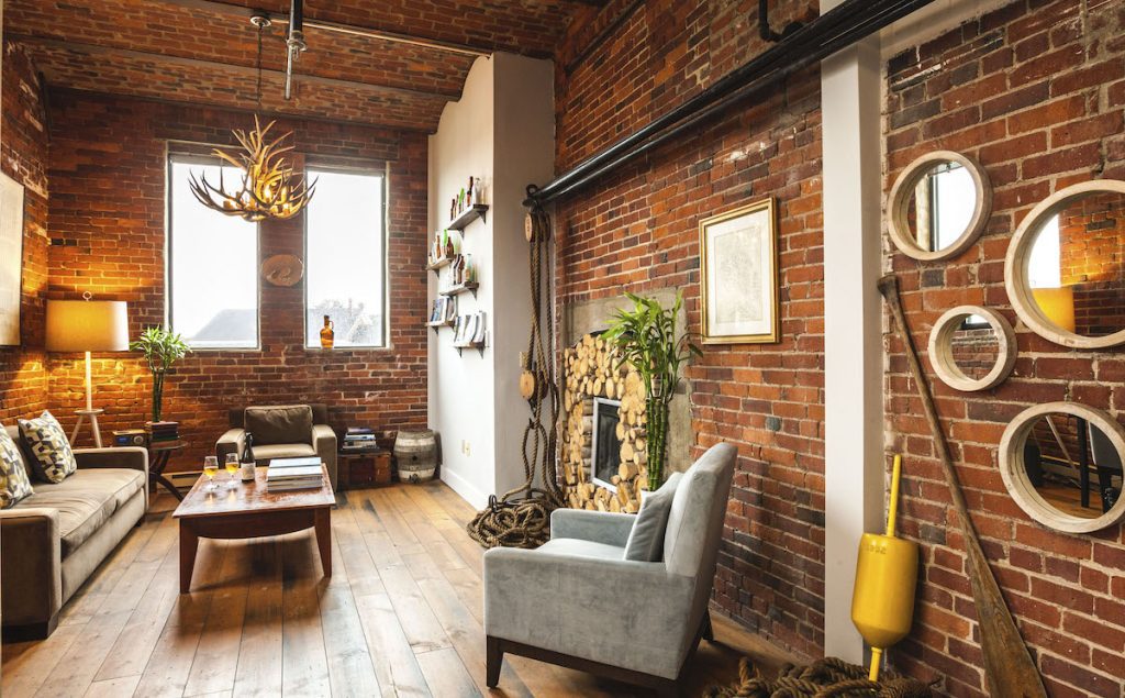 Couch and fireplace with red brick exposed walls at the Ale House Inn