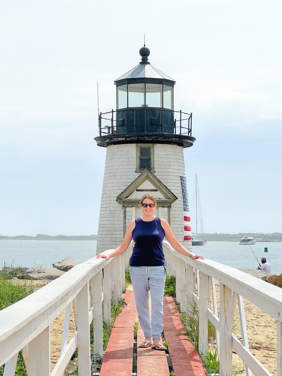 Woman in blue shirt in front of Brant Point Light 