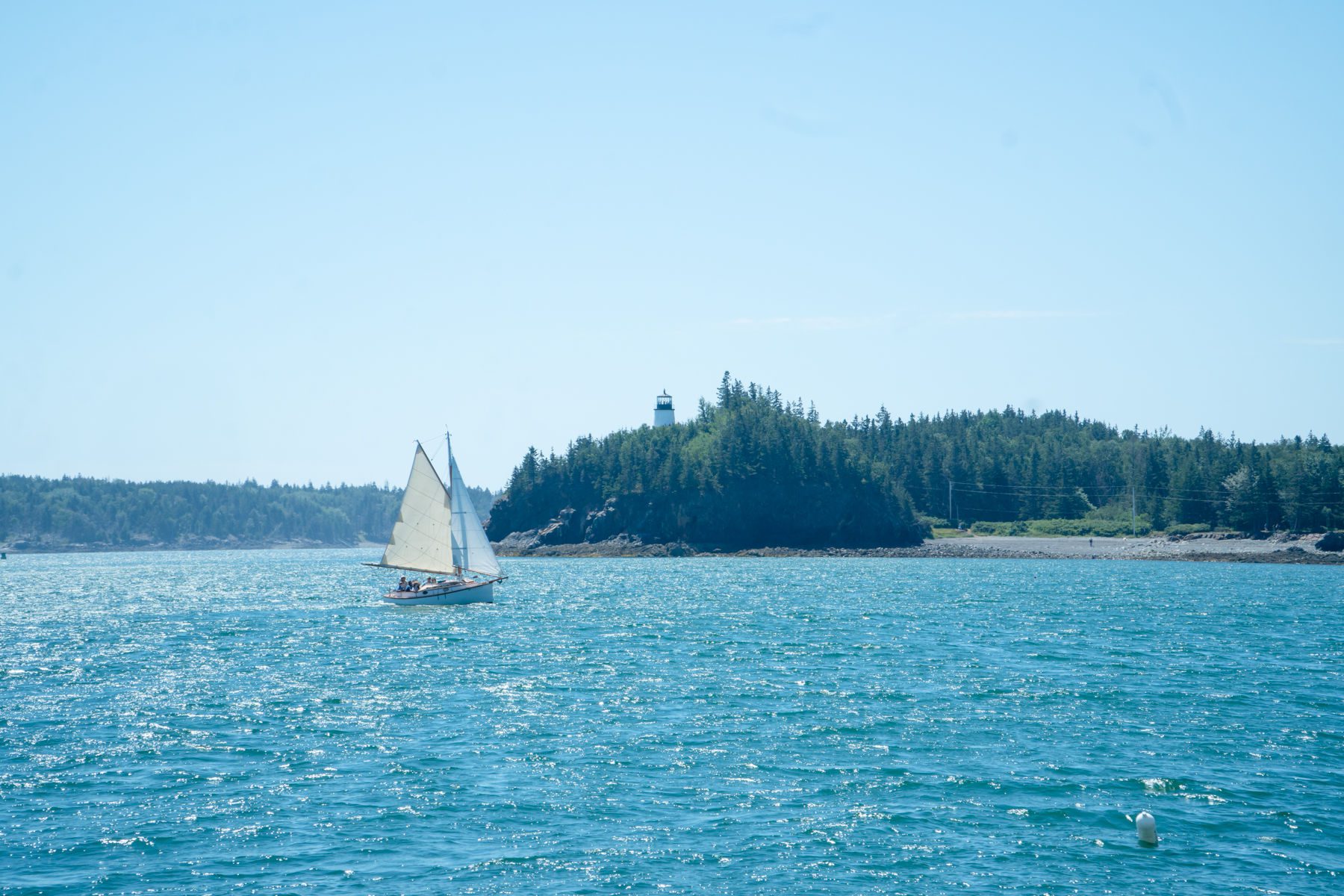 Sailboat in front of Owl Head Lighthouse