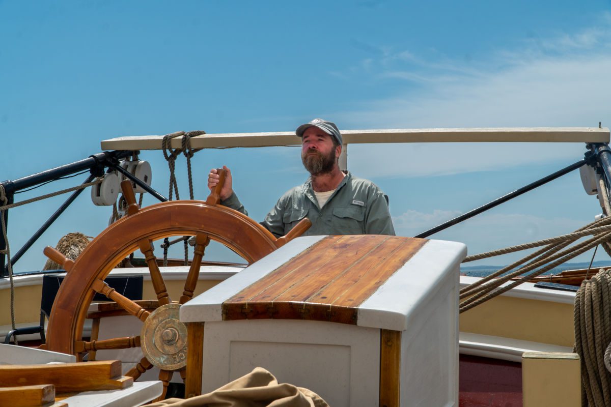 Captain Ben at the Helm of the Schooner Heritage