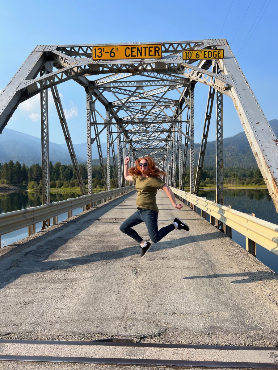 Keryn jumping on old metal bridge in Noxon Montana