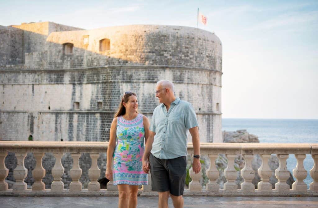 Couple walking by fort in Dubrovnik Croatia image by Valentina for Flytographer