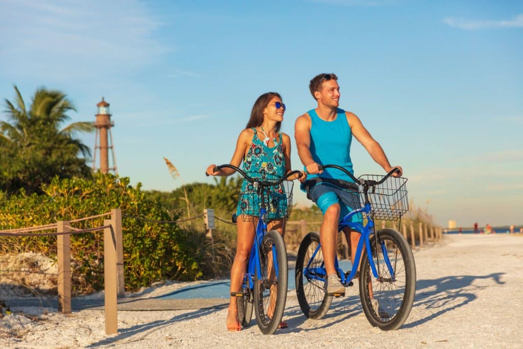Couple on beach with bikes in Florida from Depositphotos