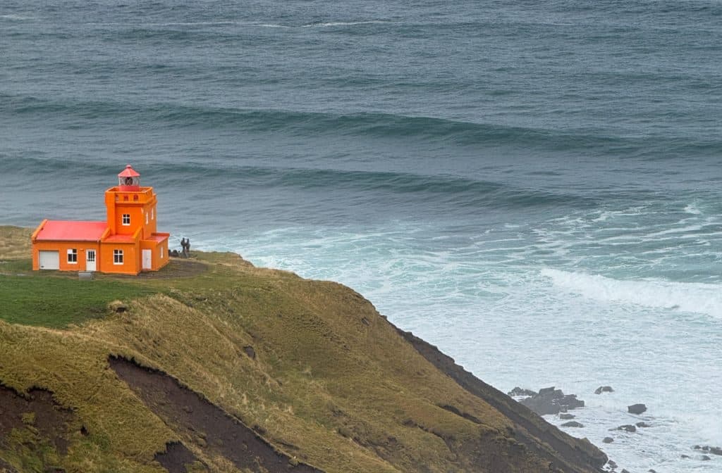 orange lighthouse on cliff by Olafsfjordur in North Iceland
